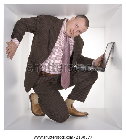 businessman with laptop in the cramped white cube