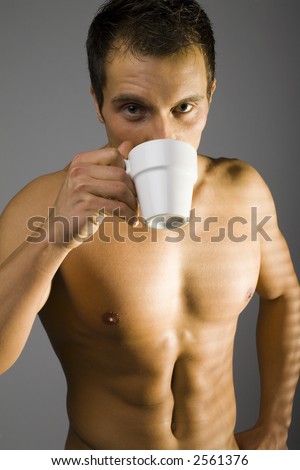 stock photo Young man standing nacked with cup of tea coffee next to the