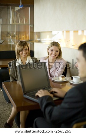 Group of People at the Cofe Table with Laptop. Short Depth of Focus (On Woman\'s in Pink Jacket Face).