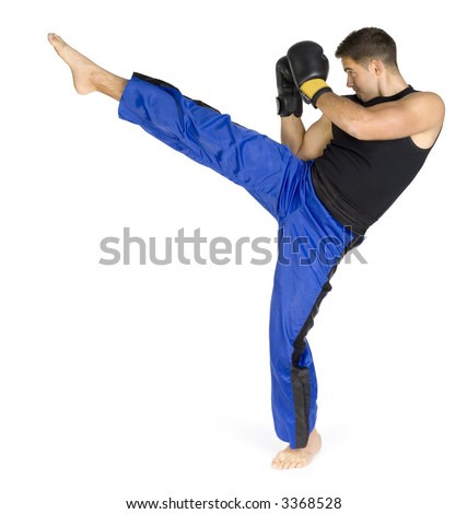 Young man in black boxing gloves doing flying kick. Isolated on white in studio. Whole body, standing backside.