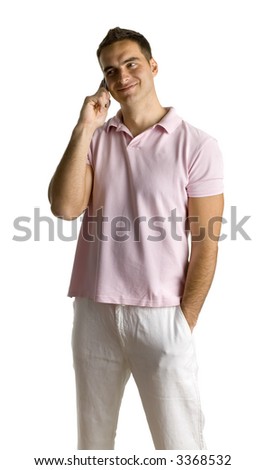 Smiling young man in pink polo shirt, talking by mobile phone. Isolated on white in studio.