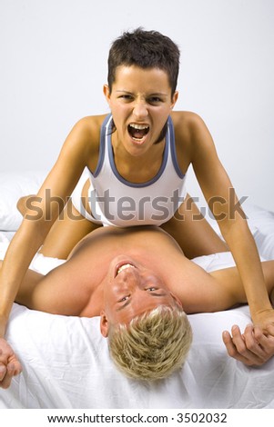 stock photo Young screaming woman sitting on man in bed showing her 