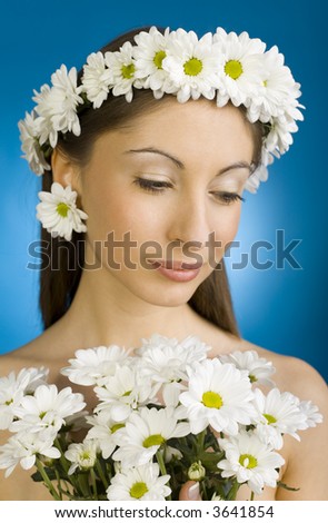 Young, beautiful and  modest woman with bouquet of white flowers. Blue background