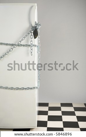 Closed fridge enwinded by chain and lock. Grey background. Front view