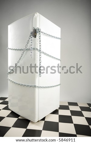 Closed fridge enwinded by chain and lock. Grey background. Side view