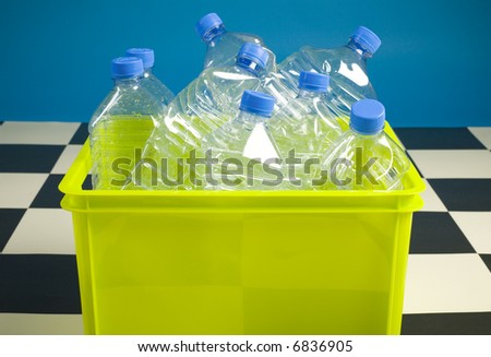 Empty bottles in green bin. Front view