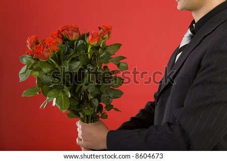 Businessman with bouquet of roses in hands. We don't see his face. Side view