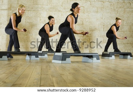 A group of women exercising with dumbbells in the fitness club. Low angle view.