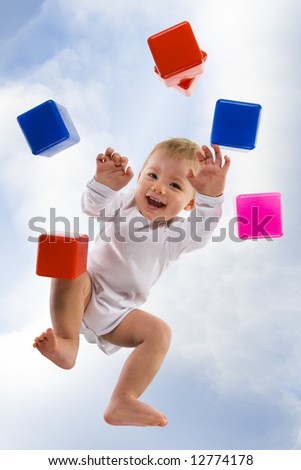 Happy little boy on all fours, looking ay camera. On the sky background. Unusual angle view - directly below.