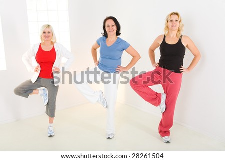 A group of exercising women. They\'re smiling and looking at camera.