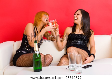 stock-photo-two-having-fun-girls-they-raising-champagne-toast-they-re-sitting-on-couch-and-smiling-front-28312897.jpg