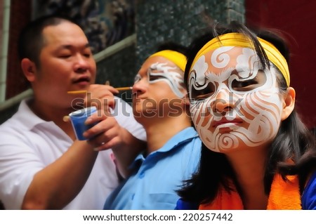 CHAIYI, TAIWAN - APRIL 26th :Before the temple fair, Face painting teacher use a brush to help The Eight of the Dead World be painted on APRIL 26th, 2014 in CHAIYI, Taiwan, Asia.