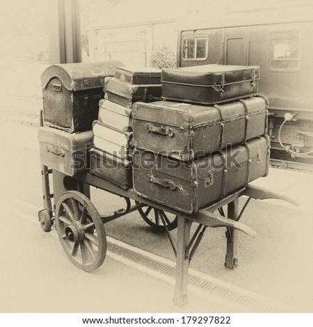 Luggage on porter\'s trolley on railways station with vintage effect filter
