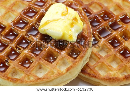Closeup of waffles with syrup and butter.