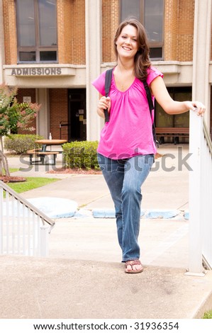 Female college student with backpack leaving admissions office at university.
