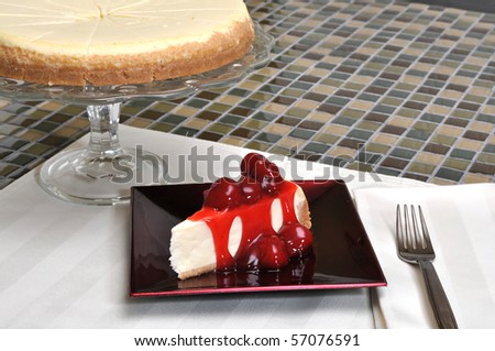 Strawberry cheesecake slice with whole cheesecake in background.