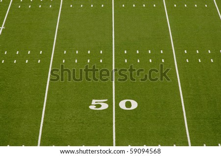 Empty American football field showing 50 yard line.
