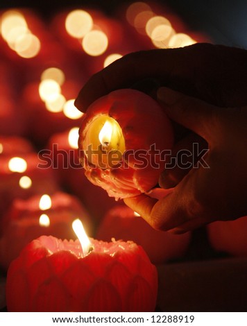 A Malaysian Chinese lights a candle for praying at a temple