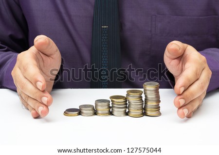 Hand protect heap coins for business or finance stability concept