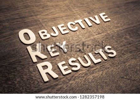 Objective Key Results (OKR) wood letters arraanged on wood background