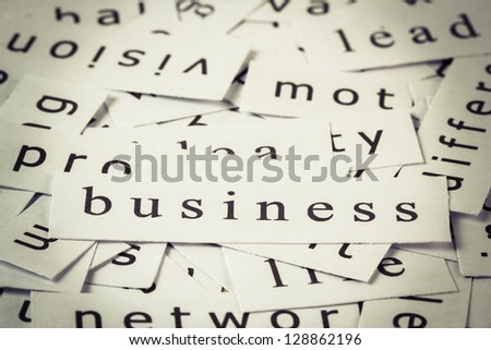 Business topic in cut paper on the top of the others word