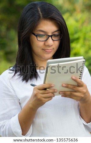 Female student reading lecture in the park