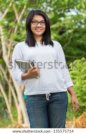 Asian female student walking in the park