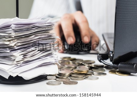 Receipts in paper nail with businessman working on laptop
