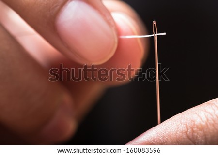 Closeup finger thread into the needle hole (Success began from a small thing)