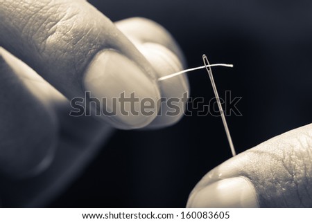 Closeup finger thread into the needle hole (Success began from a small thing)