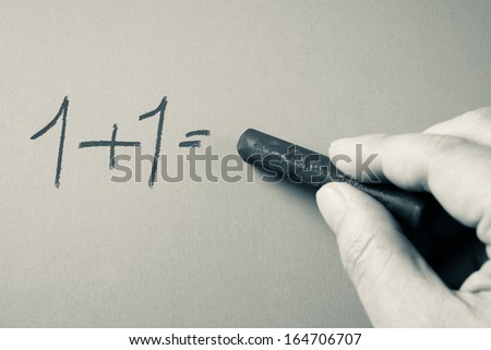 Hand writing simple mathematics  equation with chalk