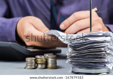Bills in paper nail with man working on background