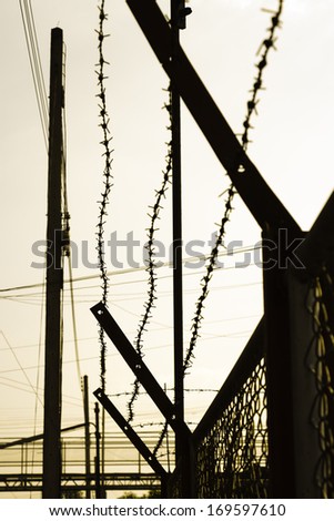 Silhouette fence and barbed wire