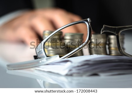 Broken eyeglasses on financial desk, losing money or business ruined concept