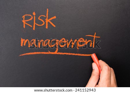 Hand underline Risk Management topic on chalkboard