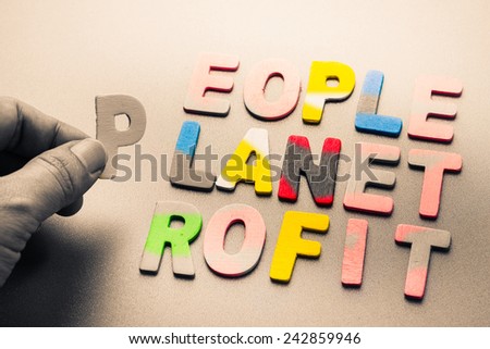 Finger pick a wood letters of People, planet, profit word