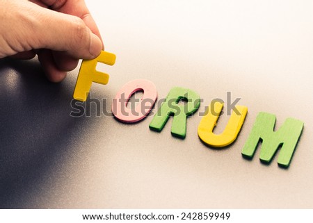 Finger pick a wood letters of Forum word