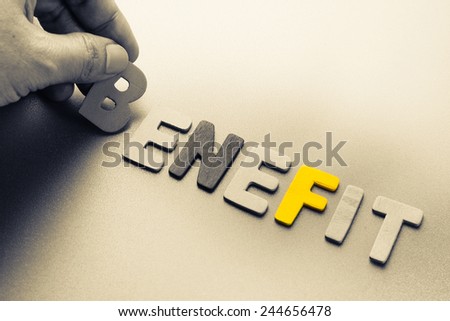 Hand arrange wood letters as Benefit word