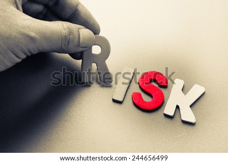 Hand arrange wood letters as risk analysis concept