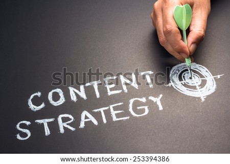 Handwriting of content strategy topic with hand put a dart hit on the target