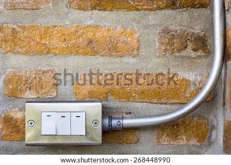 Electric switch with wire in curve metallic tube at the corner of the room