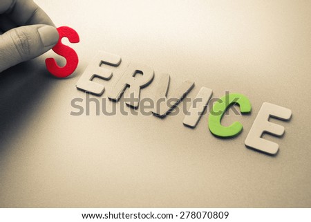 Hand arrange wood letters as Service word