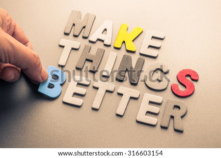 Hand arrange wood letters as Make Things Better phrase for motivation concept
