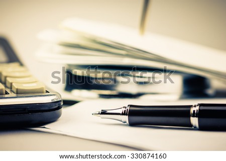 Pen on receipt with part of paper nail and calculator