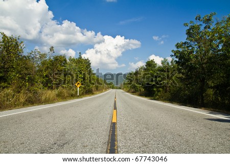 Straight road to the mountain with blue sky