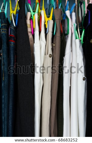 Stack of trousers with colorful hanger in the cloth shop