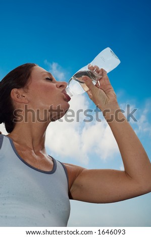 young woman drinking water after a workout