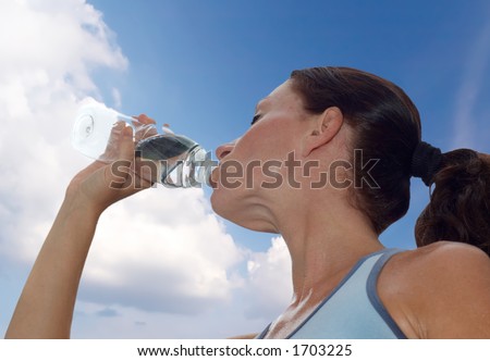 young woman drinking water after a workout