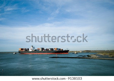 big containership being tugged into the harbor