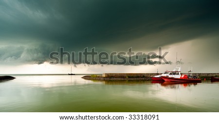 A storm cloud approaching in the harbor of a small village called Laaksum on the IJsselmeer in The Netherlands